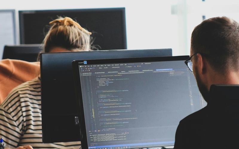 Equipo de desarrollo web programando frente a monitores