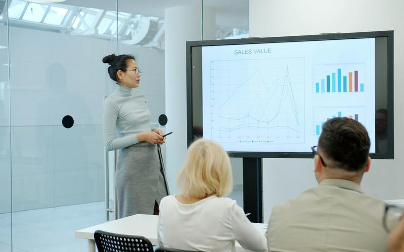 Una presentadora muestra un gráfico en pantalla a su equipo